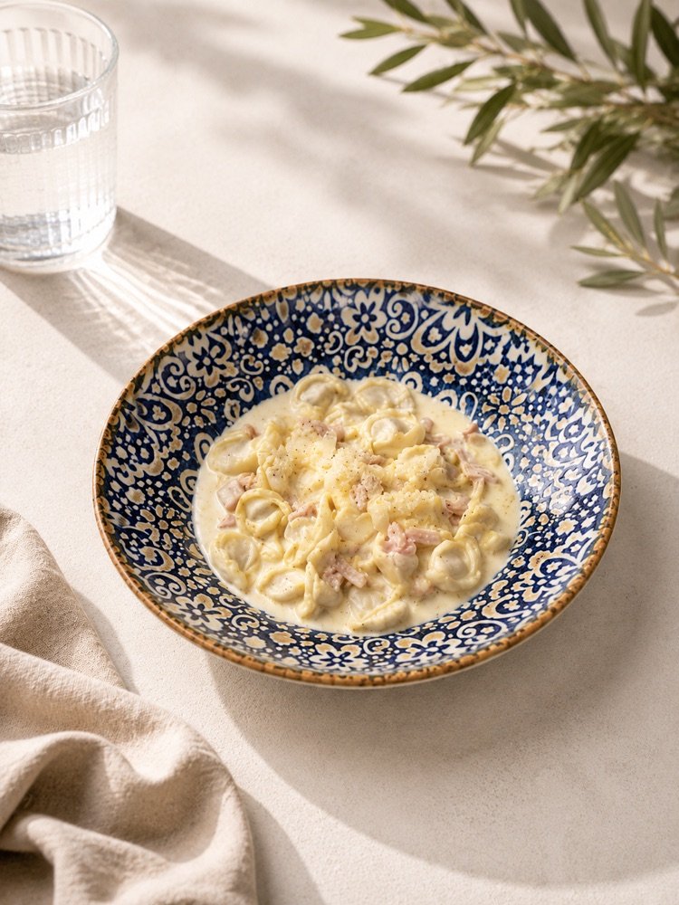 Tortellini in heller Sahnesoße mit Schinkenwürfeln, Parmesan und schwarzem Pfeffer