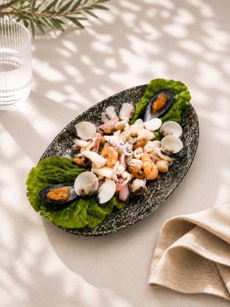 Kalter Meeresfrüchtesalat mit Miesmuscheln, Venusmuscheln, Tintenfischringen, Kraken und Garnelen
